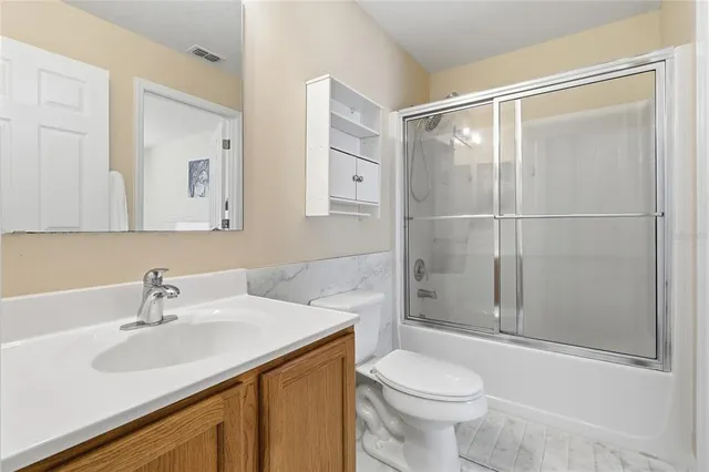 a bathroom with a double vanity sink toilet and shower