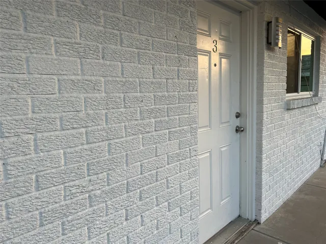 an empty room with ceiling fan and windows