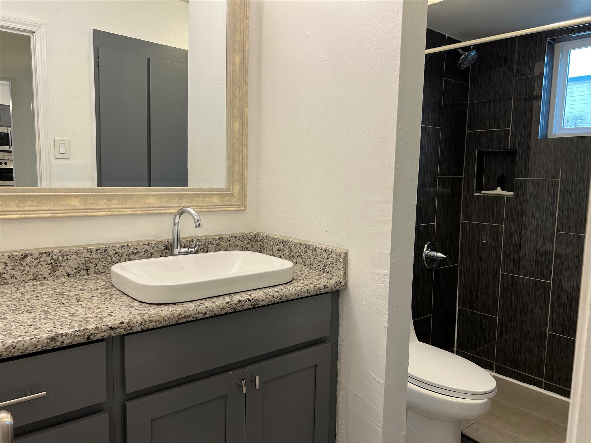 1851 West Main Street, Unit 3 Houston, TX 77098 - Photo 7 of 9 a bathroom with a granite countertop sink toilet and shower