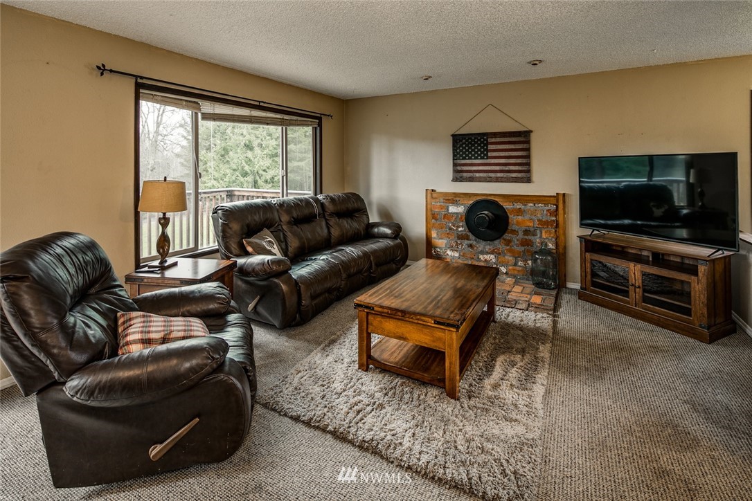 535 Kline Road Bellingham, WA 98226 - Photo 14 of 31 a living room with furniture a flat screen tv and a window