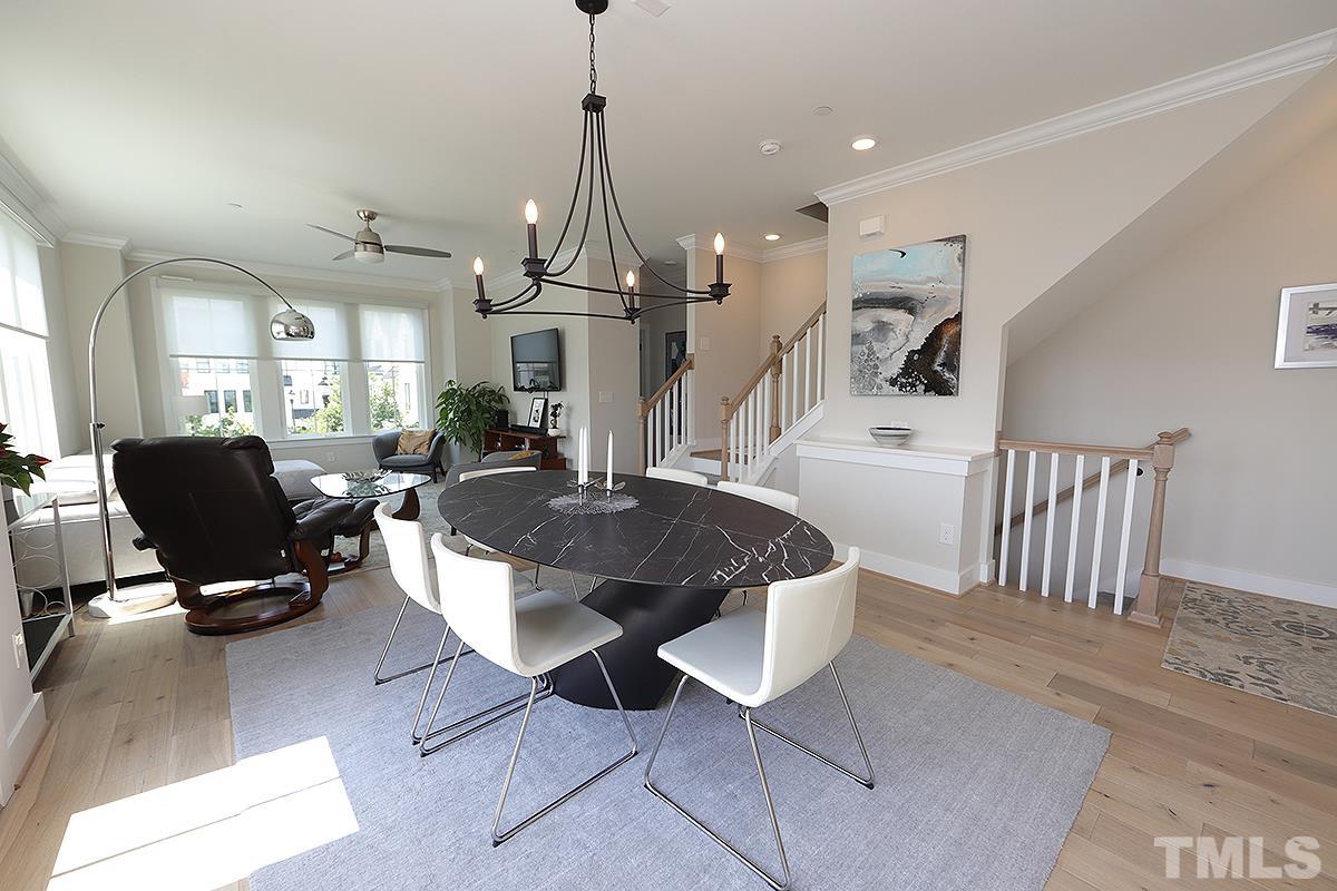 1611 Draper View Loop, Unit 101 Raleigh, NC 27608 - Photo 6 of 13 a living room with furniture a chandelier and a dining table