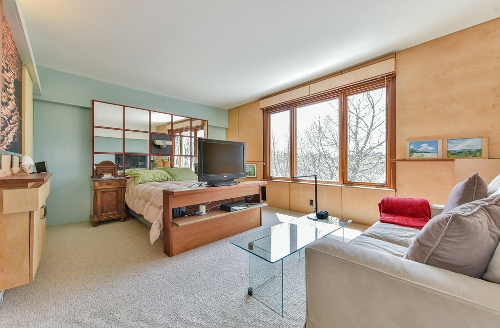 188 Rawson Road, Unit B Brookline, MA 02445 - Photo 18 of 21 a living room with furniture a flat screen tv and a floor to ceiling window