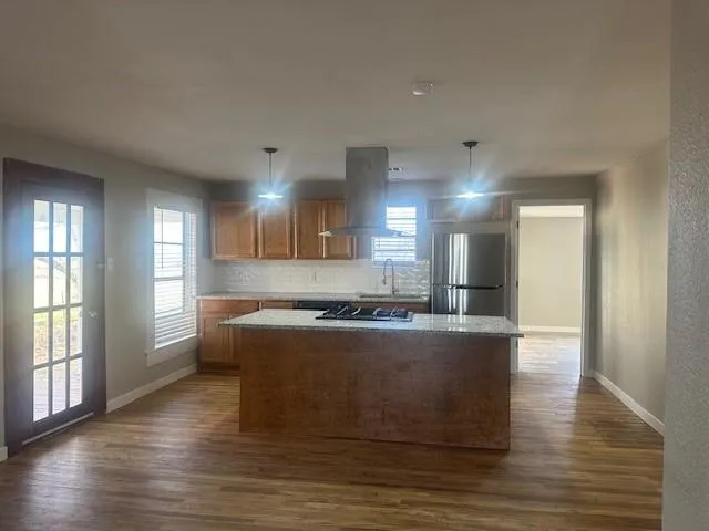 a large kitchen with stainless steel appliances granite countertop a stove a sink and a refrigerator