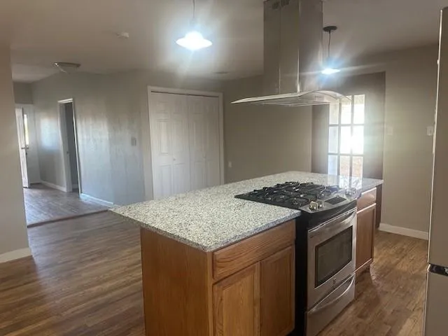 a kitchen with a stove and a wooden floor