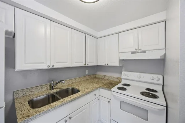 a kitchen with a refrigerator and a stove top oven