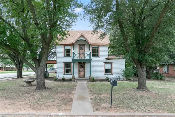 a front view of a house with a tree