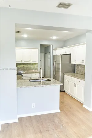 a large white kitchen with kitchen island a sink a stove and refrigerator