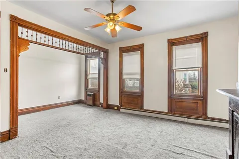 an empty room with closet and a ceiling fan