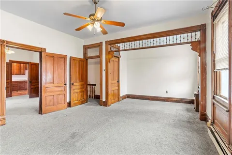 a view of an empty room with a fireplace and a window