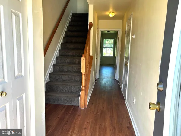 a view of a hallway with wooden floor and entryway