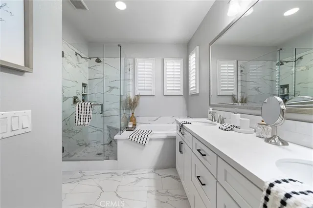 a spacious bathroom with double vanity sink a mirror and a shower