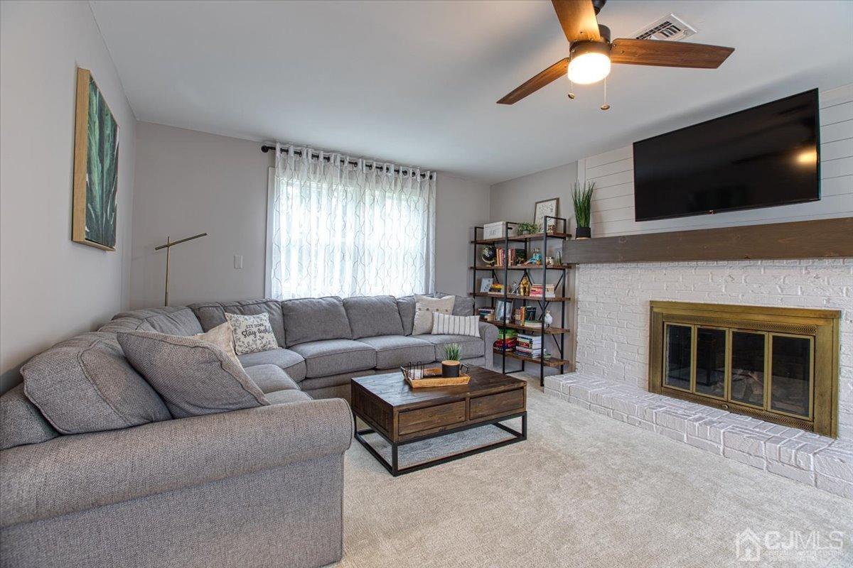 29 Clark Drive Howell, NJ 07731 - Photo 7 of 38 a living room with fireplace furniture and a flat screen tv