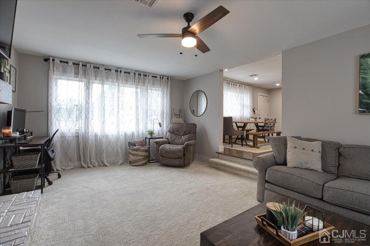 29 Clark Drive Howell, NJ 07731 - Photo 8 of 38 a living room with furniture and a chandelier