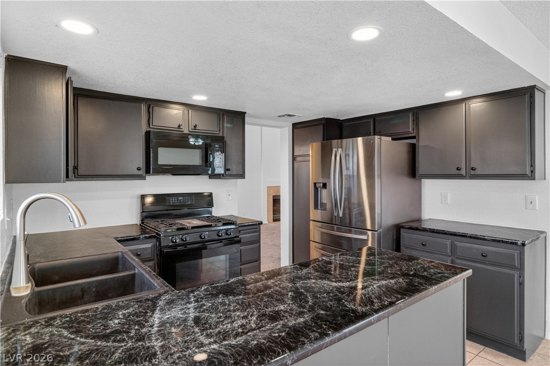 3156 Terrace View Drive Laughlin, NV 89029 - Photo 13 of 94 Culinary delights await in this modern kitchen with dark cabinetry and marbled countertops.