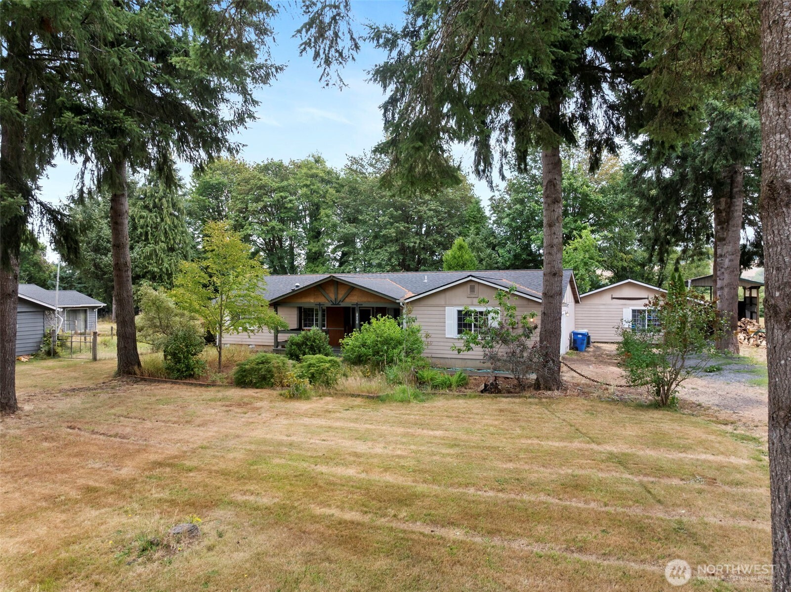 a view of a house with a yard and large trees