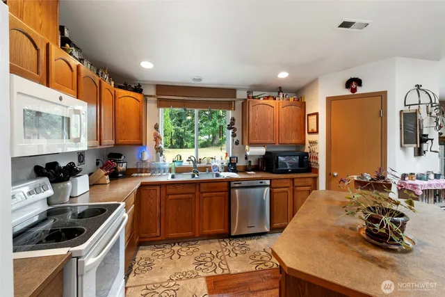 a kitchen with stainless steel appliances kitchen island granite countertop a refrigerator and microwave