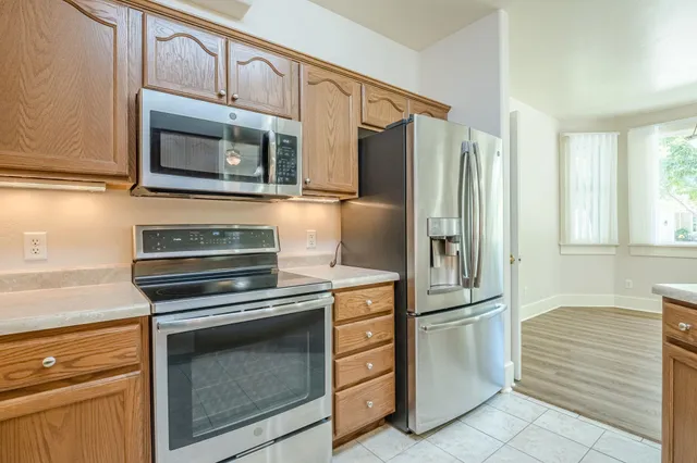 a kitchen with white cabinets and stainless steel appliances
