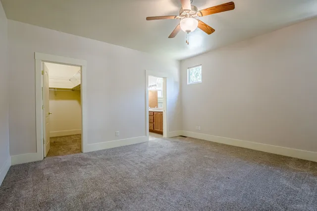 an empty room with closet and a chandelier fan