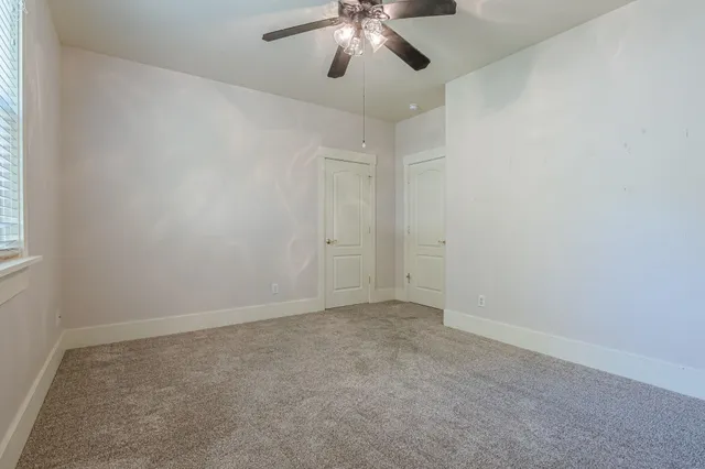 an empty room with chandelier fan