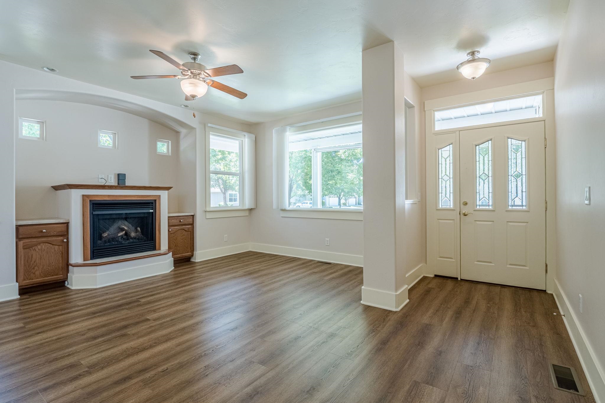 812 Alyssum Court Fruita, CO 81521 - Photo 6 of 41 an empty room with wooden floor fireplace and windows