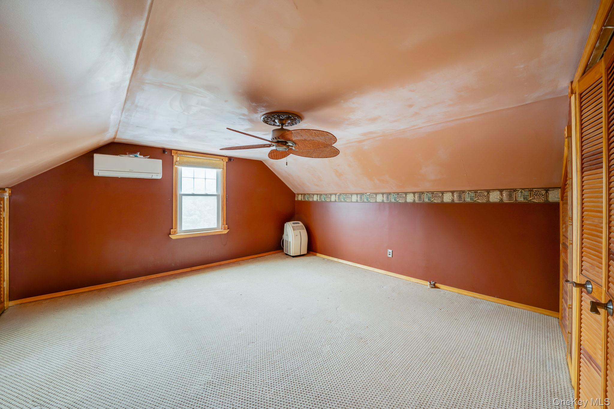 778 Terry Road Hauppauge, NY 11788 - Photo 24 of 29 Additional living space with vaulted ceiling, carpet, ceiling fan, and a wall mounted AC