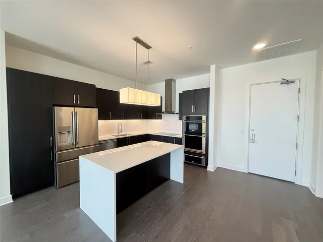 a kitchen with stainless steel appliances kitchen island a refrigerator sink and stove