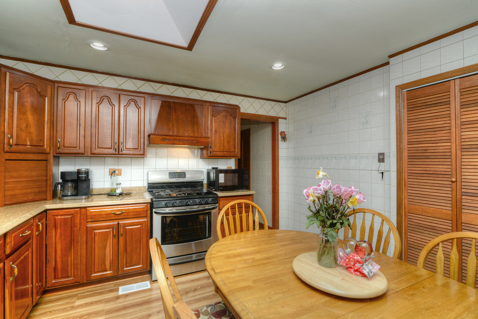 5 Butterfield Road Lake Zurich, IL 60047 - Photo 6 of 32 a kitchen with stainless steel appliances granite countertop a refrigerator a stove top oven a dining table and chairs with wooden floor