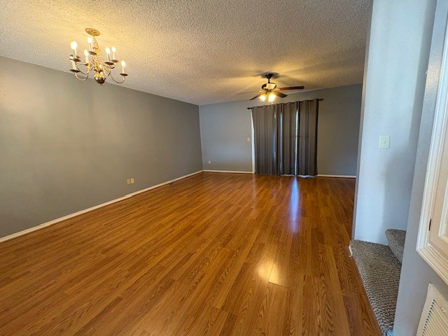 1800 Capps Road, Unit 9 Harrison, AR 72601 - Photo 8 of 18 Empty room with a chandelier, wood finished floors, a textured ceiling, and a ceiling fan