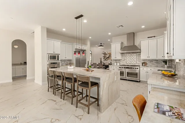 a kitchen with granite countertop white cabinets and chairs