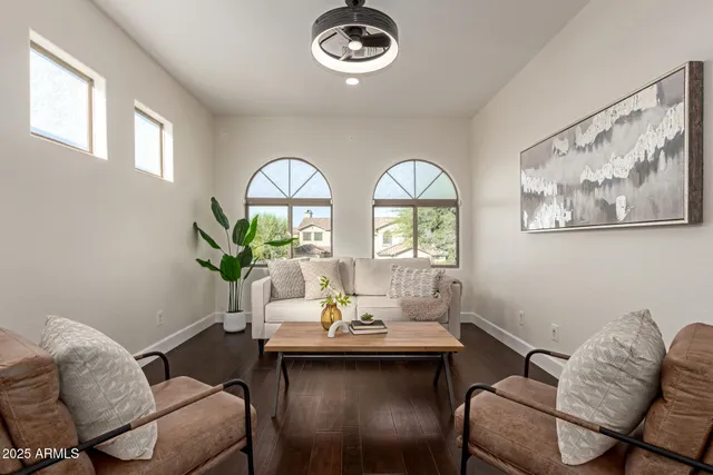 a spacious bedroom with a bed a dresser and wooden floor