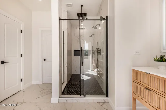 a bathroom with a granite countertop shower a mirror and a sink