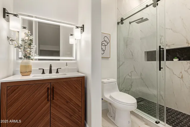 a bathroom with a sink a toilet and shower