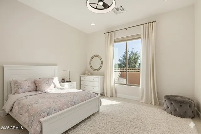 a bedroom with a bed and a large window