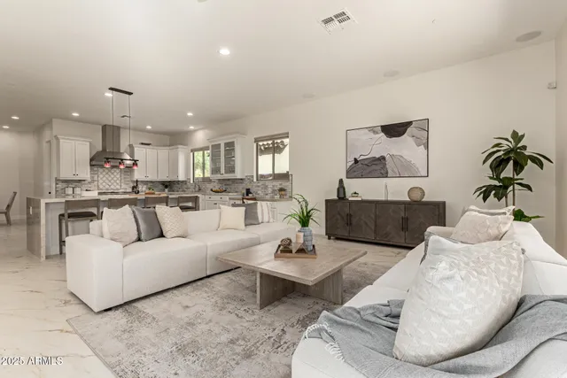 a view of a dining room and livingroom with furniture wooden floor a chandelier