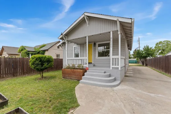 a front view of a house with a yard and potted plants