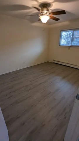 a view of a room with wooden floor and a window