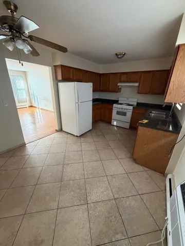 a kitchen with granite countertop a stove a sink and a microwave