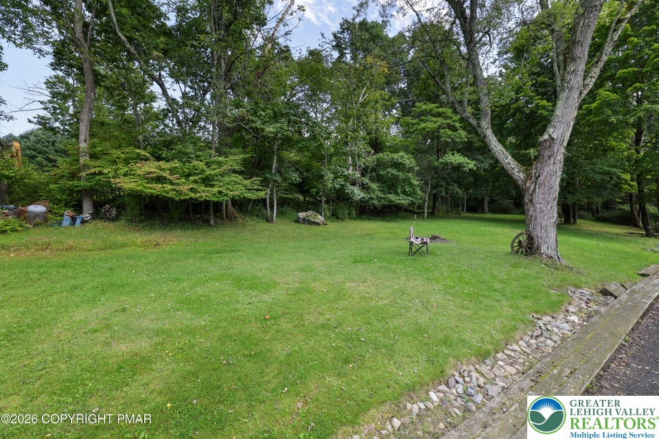 1207 Seese Hill Road Canadensis, PA 18325 - Photo 32 of 49 Mature trees frame a grassy lawn, offering a serene outdoor setting.