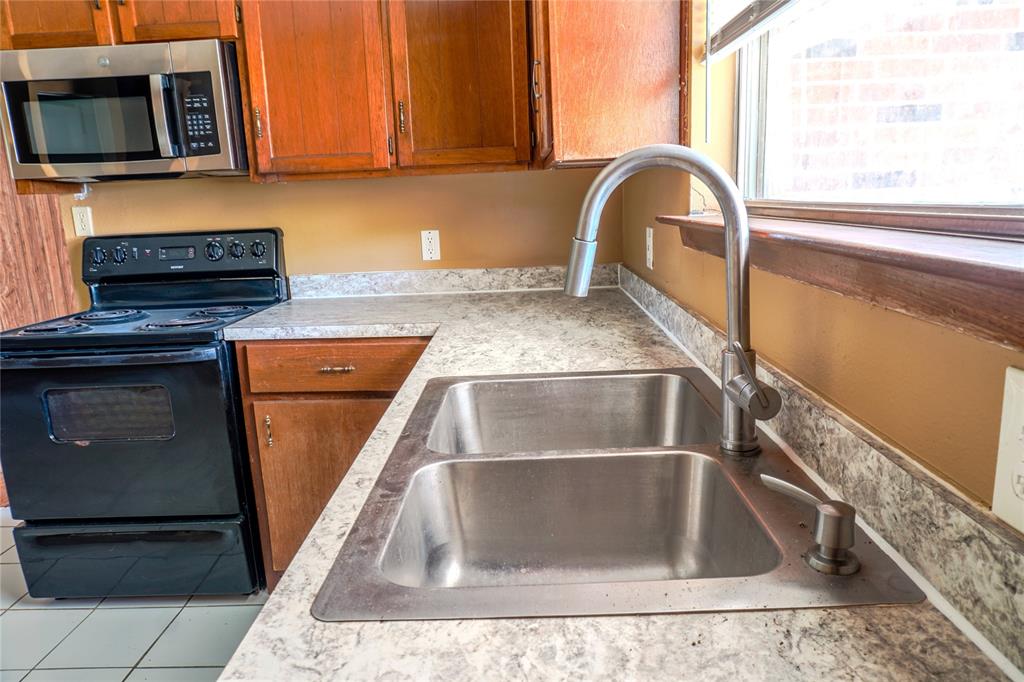 300 Coury Road Everman, TX 76140 - Photo 8 of 29 a kitchen with a sink and a microwave