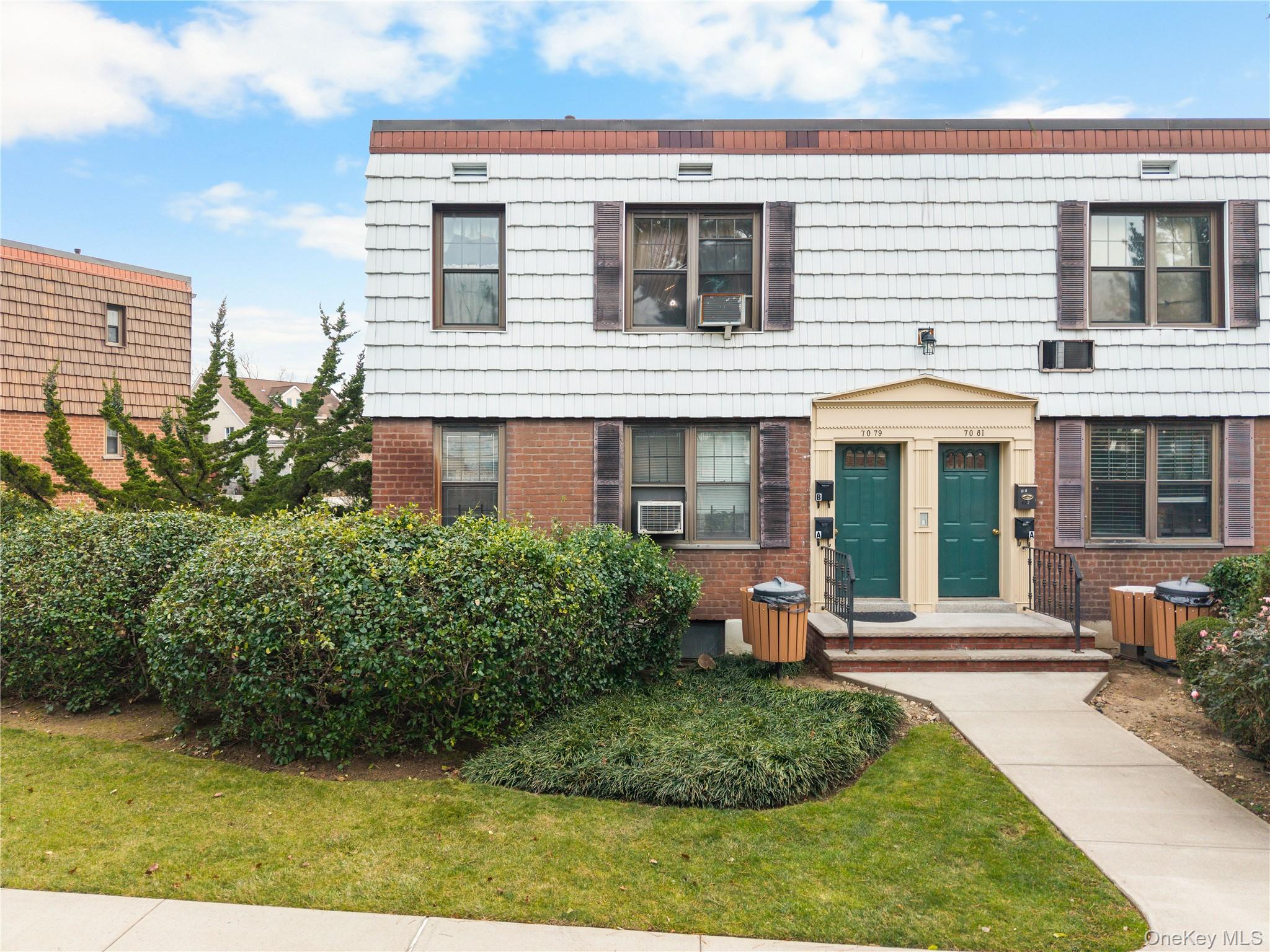 Colonial inspired home featuring brick siding and a front lawn