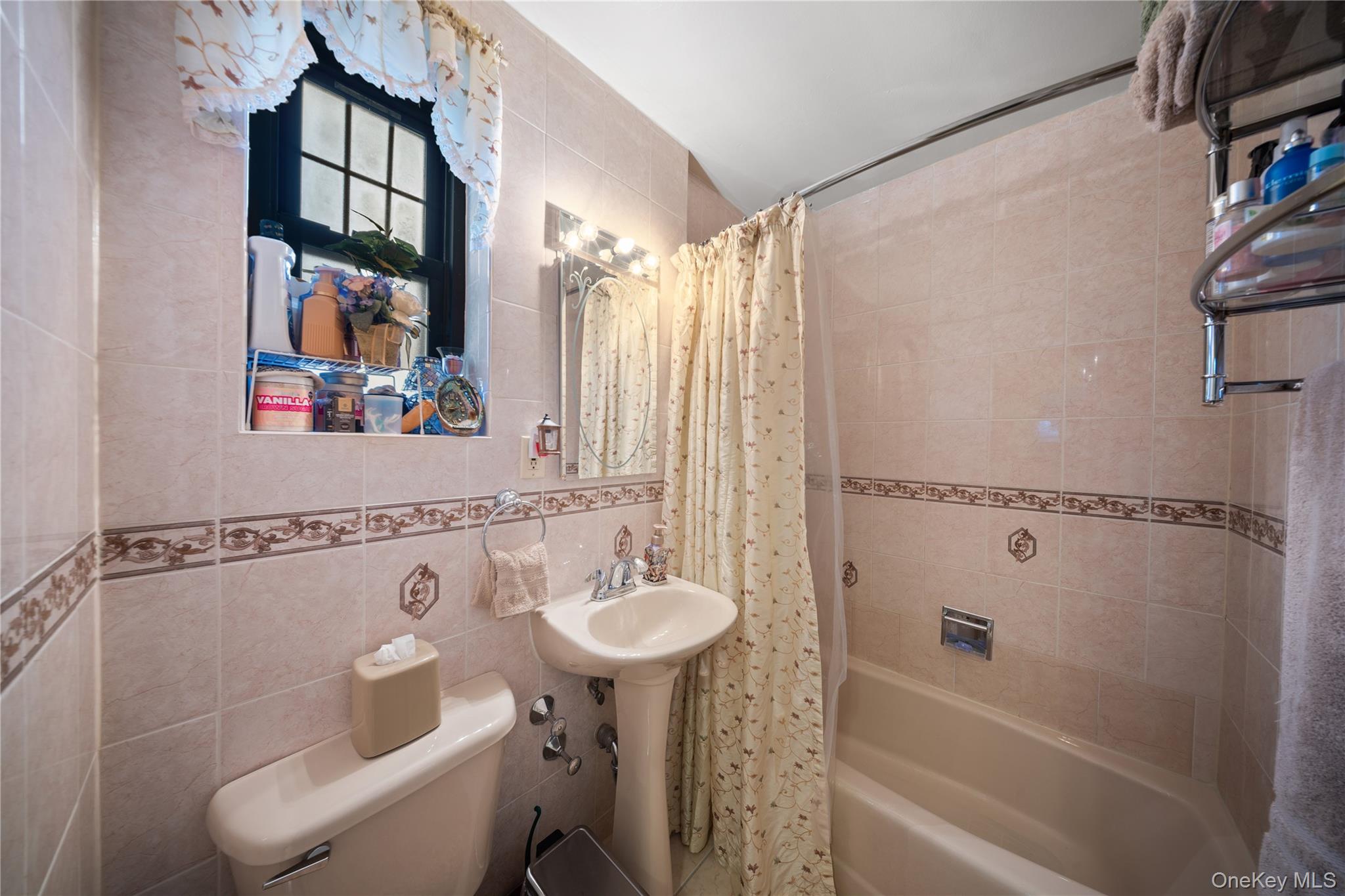 70-79 Park Drive East, Unit B Queens, NY 11367 - Photo 10 of 25 Bathroom with tile walls and shower / bath combo with shower curtain