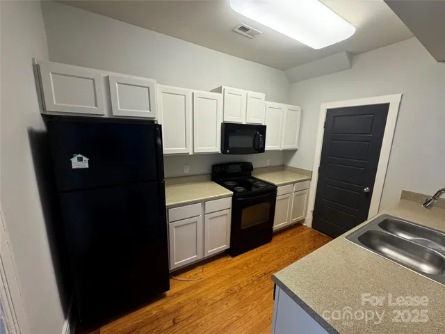 a kitchen with granite countertop a refrigerator stove and microwave
