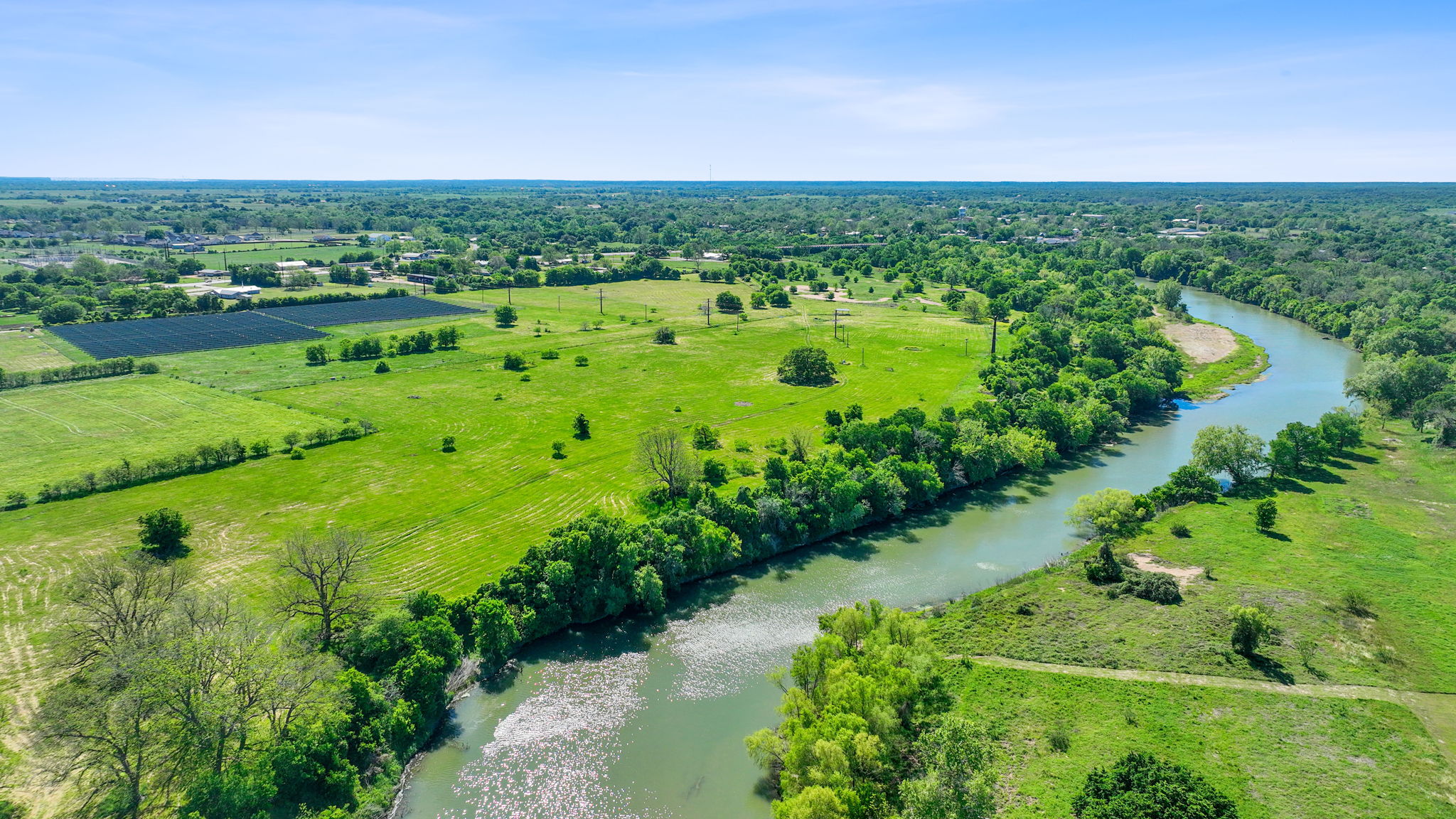 663 Sh 230 Loop Smithville, TX 78957 - Photo 16 of 36 a view of a green field with lots of plants and trees in the background