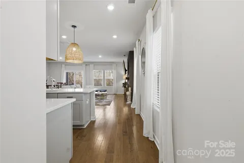 a view of open kitchen with cabinets and wooden floor