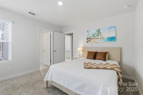 a bedroom with a bed and a painting on the wall