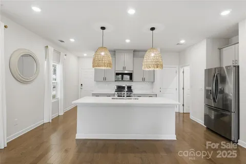 a view of a kitchen with kitchen island a sink stainless steel appliances and cabinets