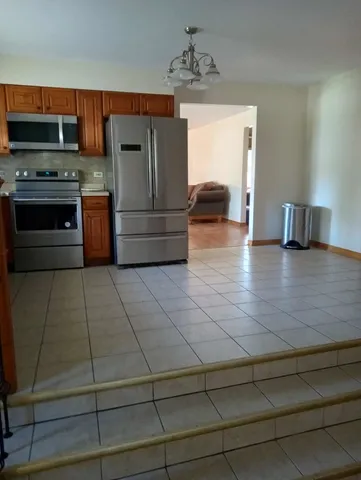 a kitchen with kitchen island granite countertop a stove and a cabinets