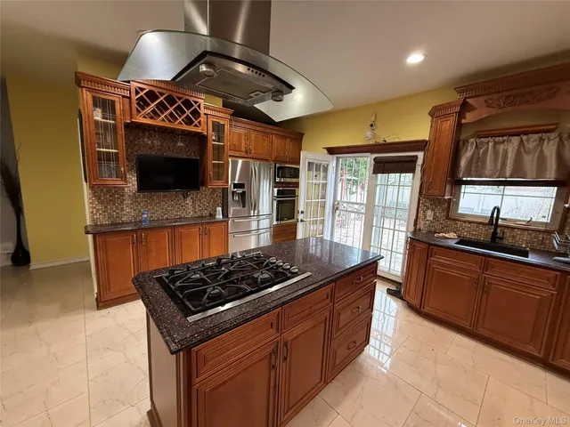 a kitchen with kitchen island granite countertop a sink and a stove