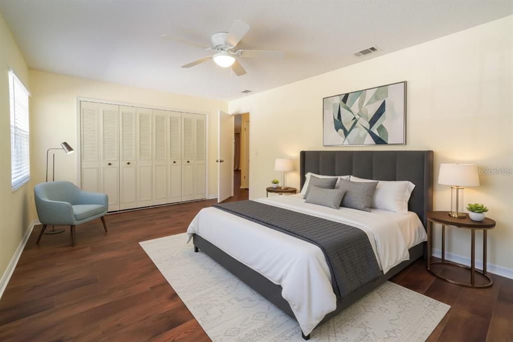 6260 Morning Mist Lane Orlando, FL 32819 - Photo 19 of 27 a spacious bedroom with a bed and a chandelier