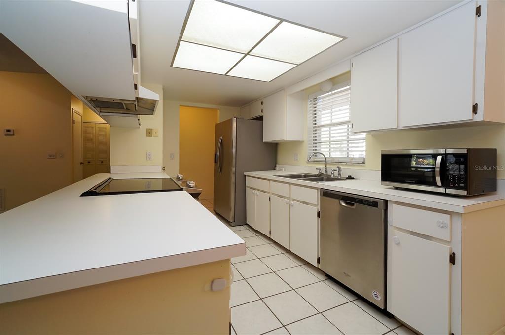 6260 Morning Mist Lane Orlando, FL 32819 - Photo 2 of 27 a kitchen with a sink a stove a microwave and cabinets